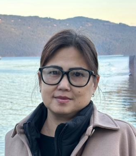 Person by scenic lake and mountains