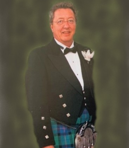Person in formal attire with tartan kilt smiling.