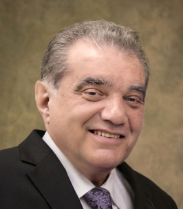Smiling man in suit with gray background.