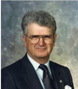 Elderly man in suit with glasses, formal portrait.