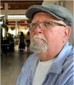 Man in glasses and cap looking away indoors.