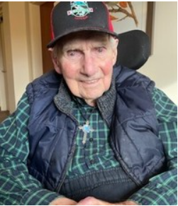 Elderly man smiling in a cozy room.