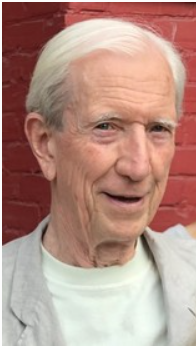 Smiling elderly man with white hair and red wall.