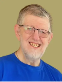 Smiling person wearing glasses and blue shirt.