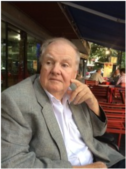Man in gray suit sitting at outdoor café