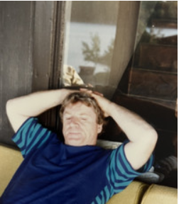 Person relaxing on couch with hands on head