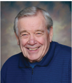 Smiling elderly man in blue sweater portrait.