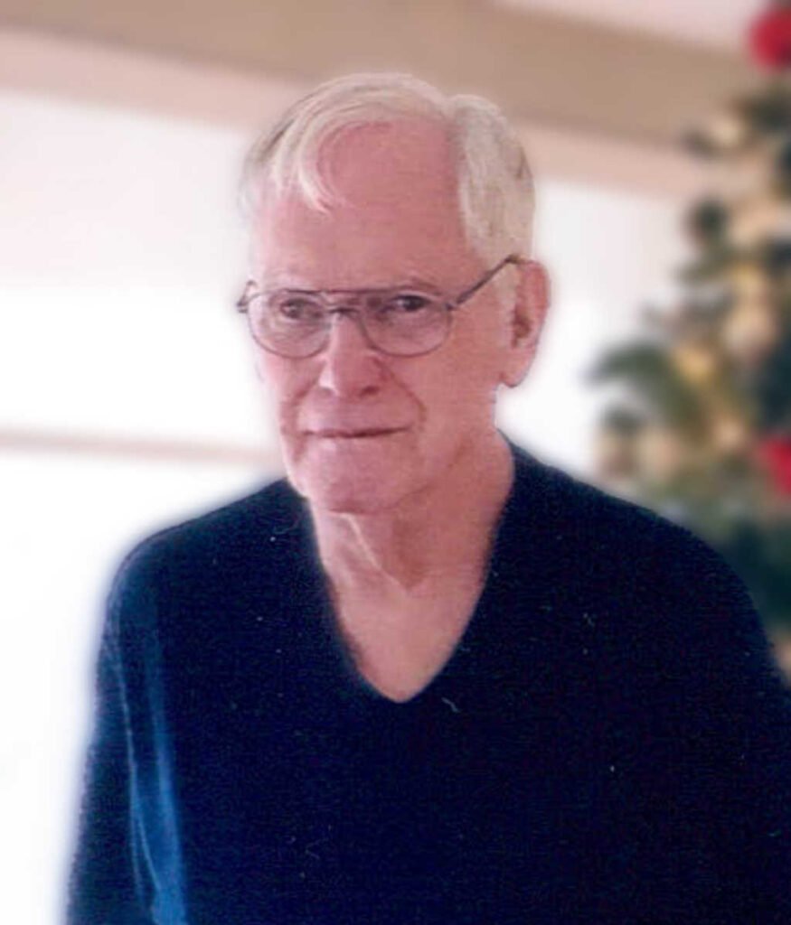 Elderly man smiling indoors.