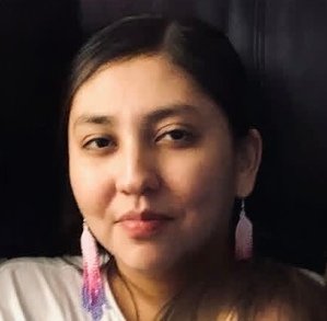 Person with long earrings smiling