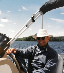 Man driving boat on sunny lake day.