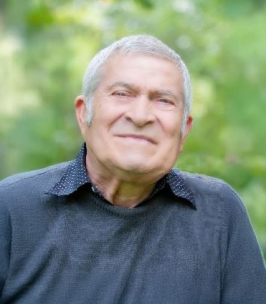 Smiling man outdoors with green background