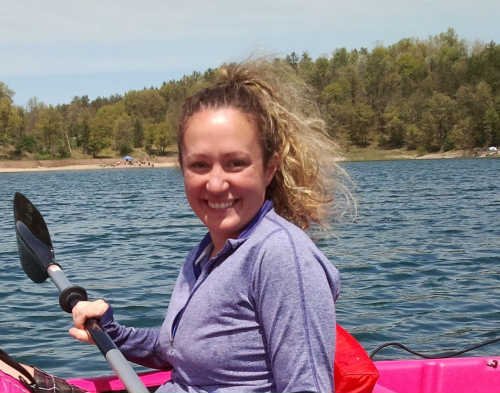 Woman kayaking on a lake on a sunny day