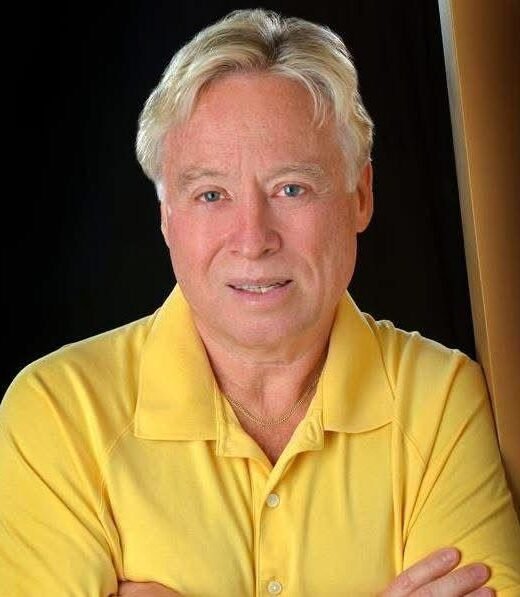 Man in yellow shirt against dark background