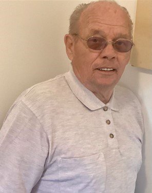 Elderly man wearing glasses and a collared shirt