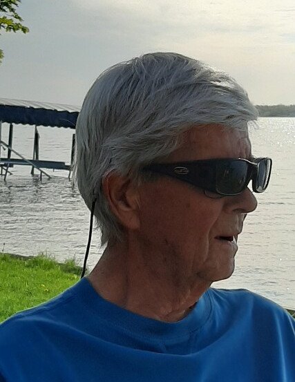 Elderly man wearing sunglasses by a lake