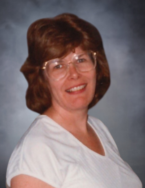 Smiling woman with glasses and short hair.