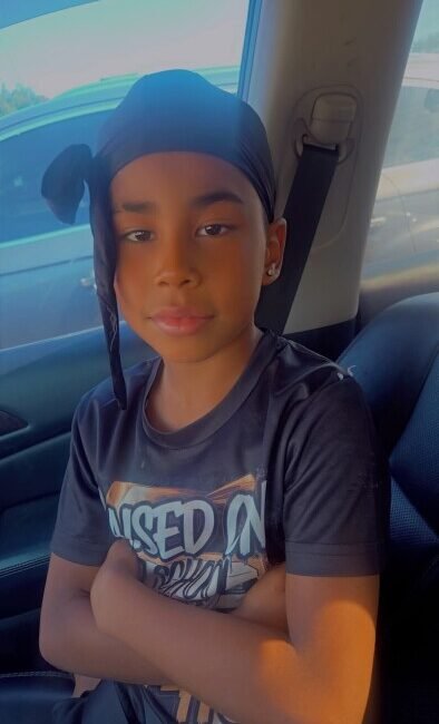 Child sitting in car wearing a headscarf