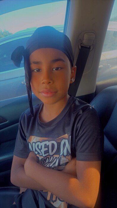 Child sitting in car wearing a headscarf