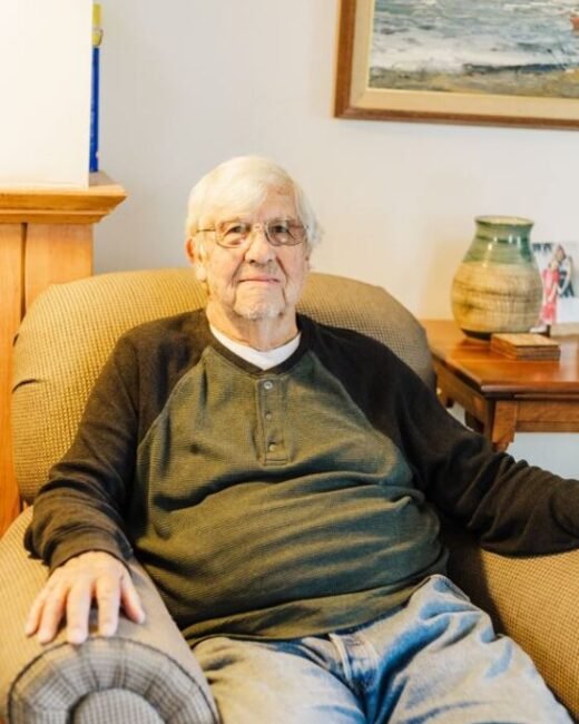 Elderly man sitting in a comfortable chair at home.