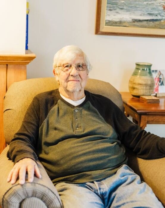 Elderly man sitting in a comfortable chair at home.