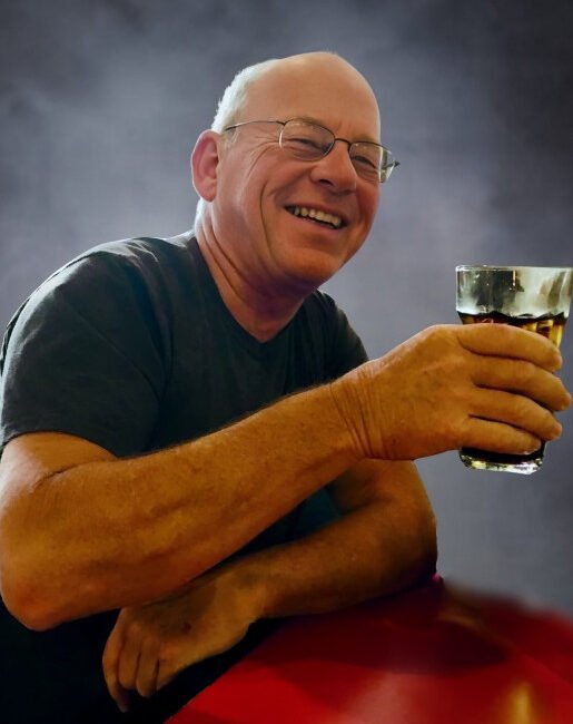 Man smiling and holding a drink