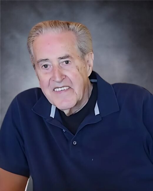 Smiling elderly man in a blue shirt portrait.