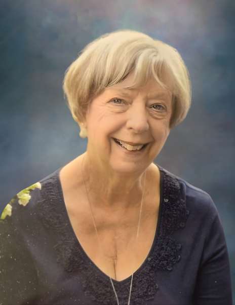 Smiling elderly woman with short hair, blue background.