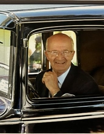 Smiling man sitting in vintage car