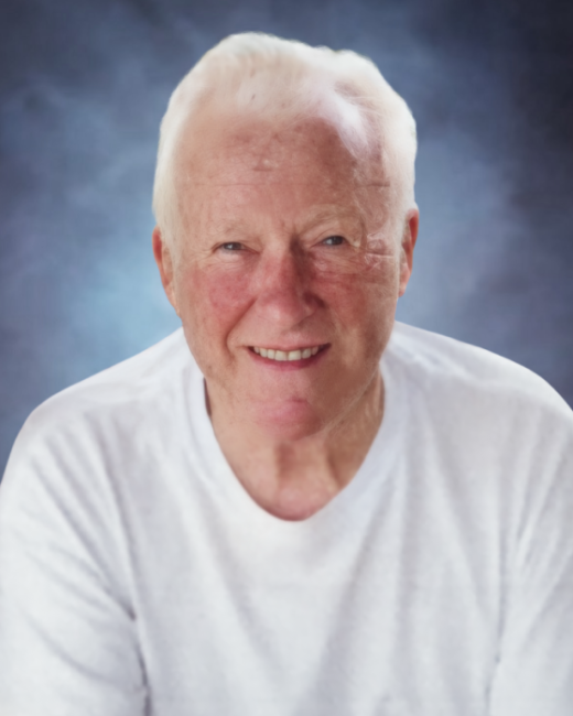 Smiling elderly man with white hair in white shirt.