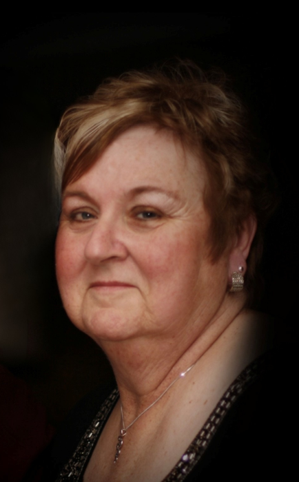 Smiling person with short hair and earrings