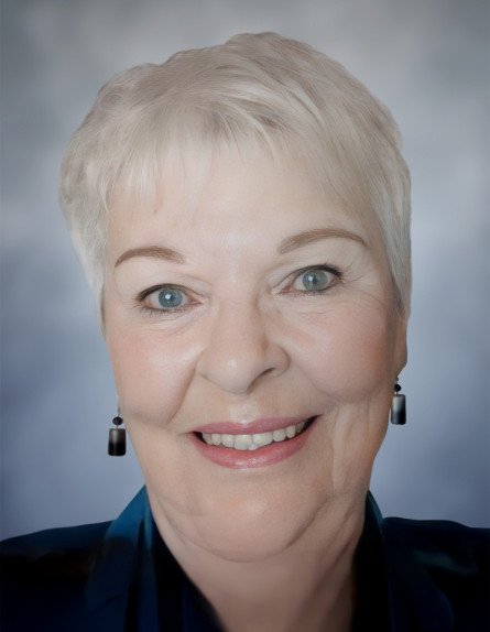 Smiling woman with short white hair and earrings.