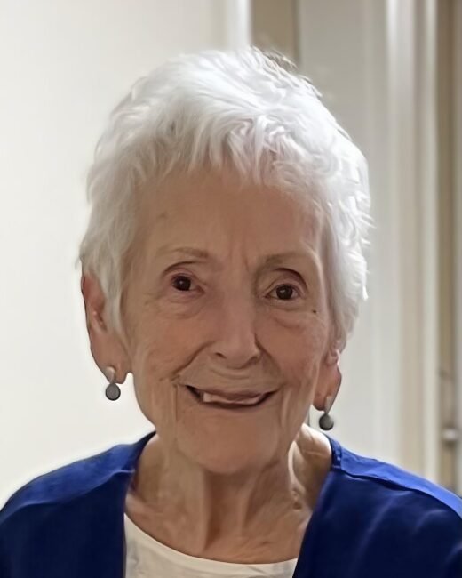 Smiling elderly woman with short white hair.