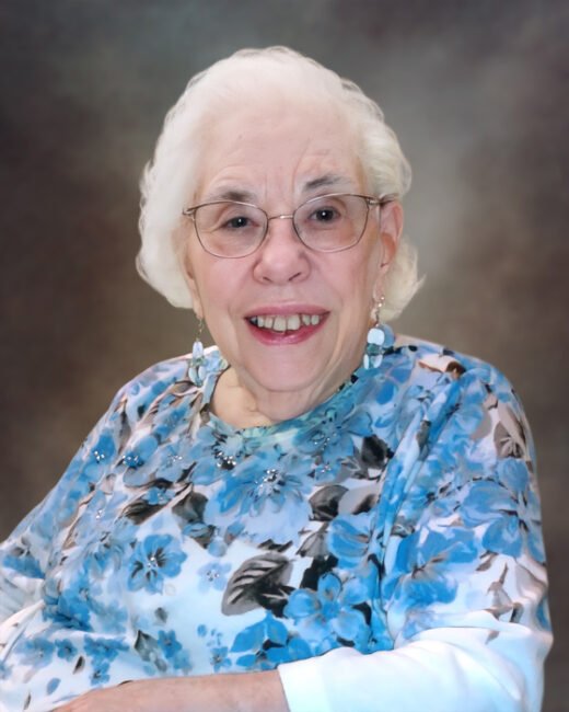 Smiling elderly woman with white hair and floral shirt