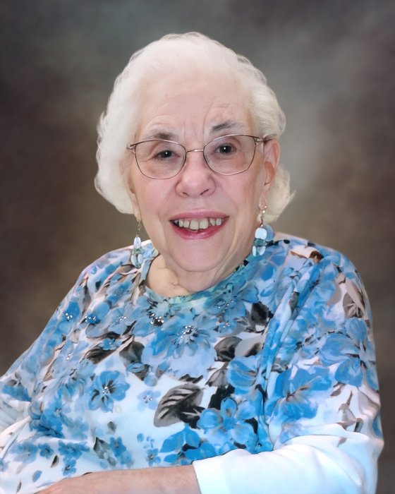 Smiling elderly woman with white hair and floral shirt