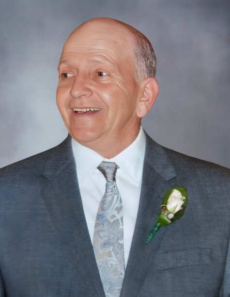 Smiling man in suit with flower boutonniere.