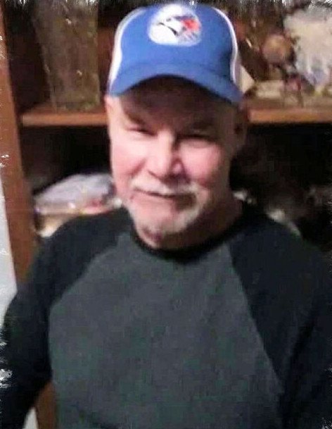 Man wearing baseball cap and smiling indoors.