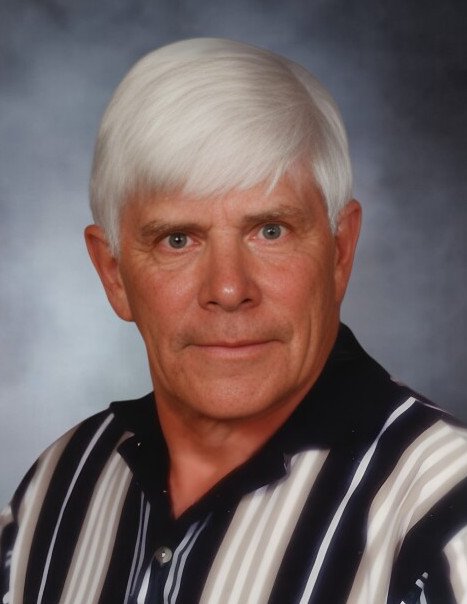 Elderly man with white hair in striped shirt.