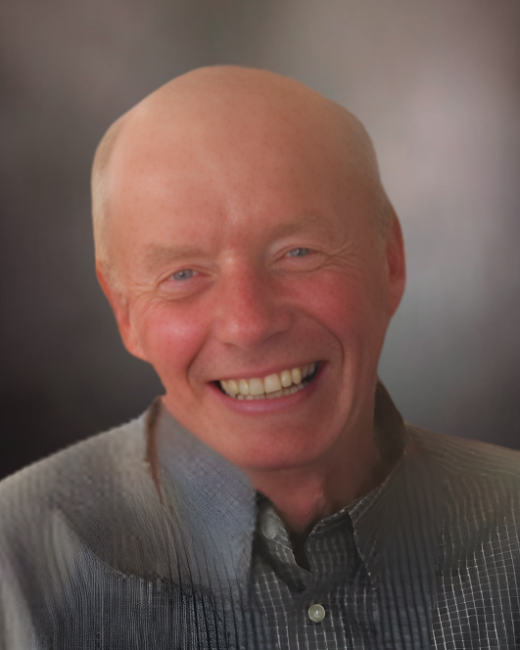 Smiling bald man in checkered shirt portrait.