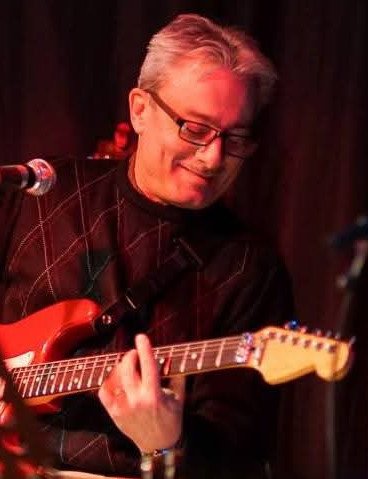 Musician playing electric guitar on stage