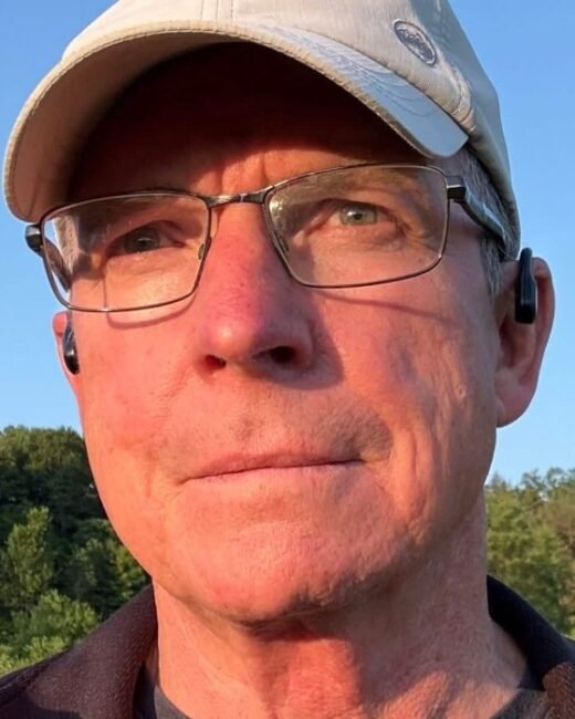 Man outdoors wearing glasses and cap