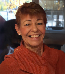 Smiling woman in orange sweater indoors