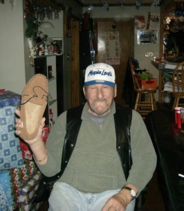 Man holds moccasin in festive room