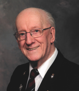 Elderly man smiling in suit and tie portrait.