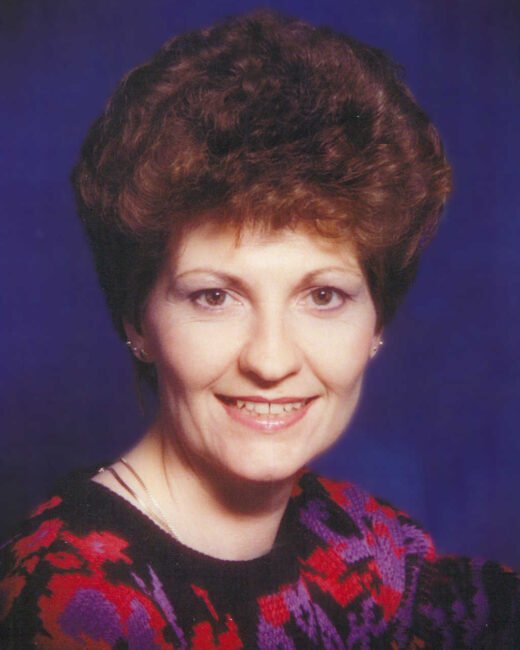 Woman smiling with colorful sweater, blue background.