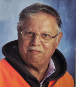 Elderly man wearing orange jacket against blue background