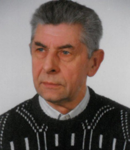 Elderly man with gray hair wearing a sweater.