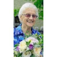 Smiling elder holding colorful bouquet.