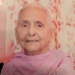 Smiling elderly woman in a pink shawl.