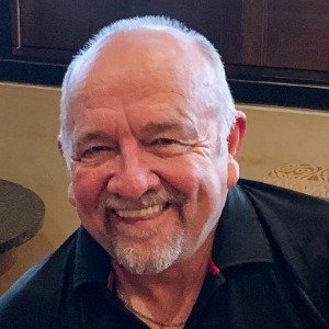 Smiling man with a gray beard indoors