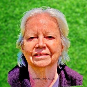 Elderly person outdoors with green grass background.